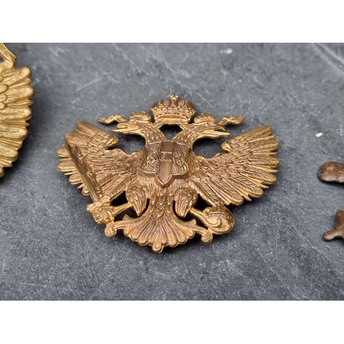 239 - A Prussian gilt metal pickelhaube helmet front badge, 9cm high; together with various other military... 