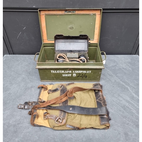 321 - A British military green tin box, containing a field telephone; and a German pony fur backpack.... 