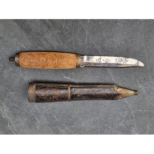 81 - A vintage Scandinavian filching knife and sheath, with 9cm single edged blade and carved wooden hand... 