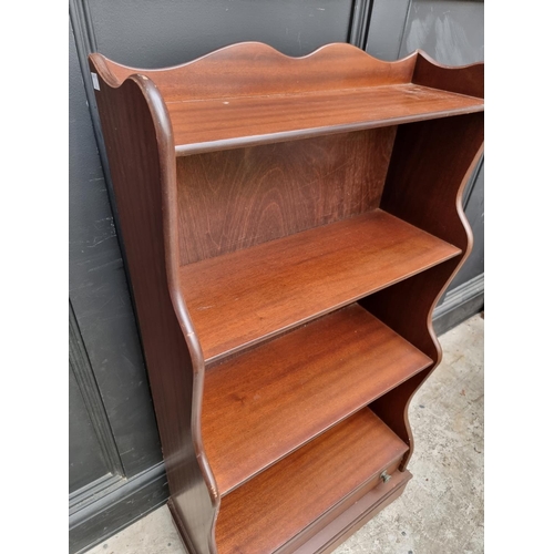 1014 - A reproduction mahogany waterfall bookcase, with apron drawer, 56.5cm wide.  ... 