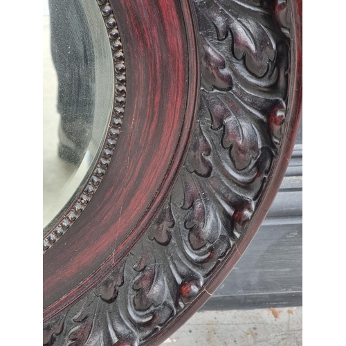 1023 - A large stained composition frame oval wall mirror, 99 x 74cm.