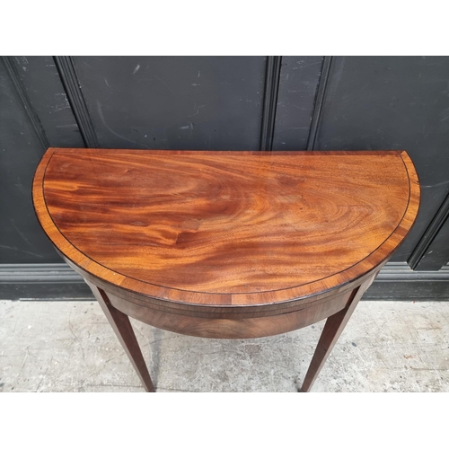 1056 - A George III mahogany and line inlaid demi-lune tea table, with double gateleg action, 95cm wide.... 