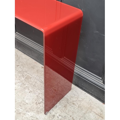 1121 - An Italian red glass console table, 101cm wide.