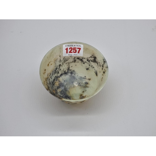 1257 - A Chinese mottled green jade bowl, 9.8cm diameter.