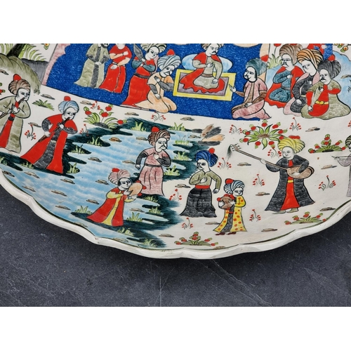 1348 - A Turkish pottery charger, painted with an emperor and attendants, inscribed to base, 38cm diameter.... 