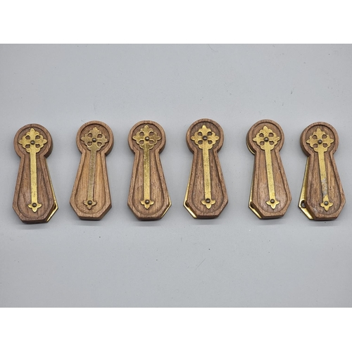 1483 - A set of six Gothic oak and brass escutcheons, 6.5cm high.