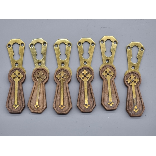 1483 - A set of six Gothic oak and brass escutcheons, 6.5cm high.