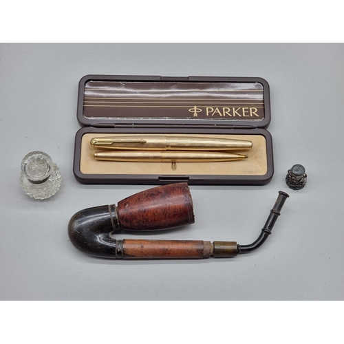 1491 - A Parker gilt metal fountain pen, boxed; together with a similar propelling pencil; a pipe; and two ... 