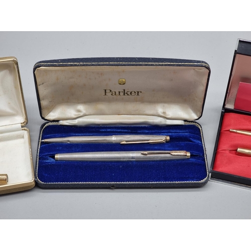 1502 - A group of vintage pens, comprising: a cased Parker silver pen set, circa 1964, (s.d. to one); a Par... 