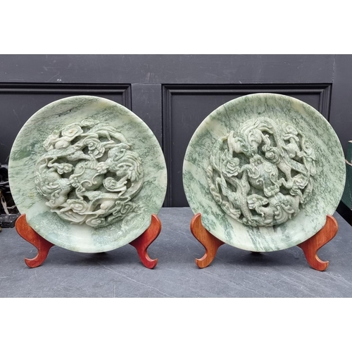 1550 - A large pair of Chinese carved mottled green jade relief chargers, decorated with dragons, 35cm diam... 