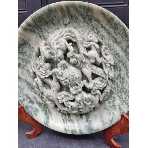 1550 - A large pair of Chinese carved mottled green jade relief chargers, decorated with dragons, 35cm diam... 