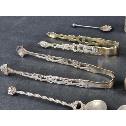 287 - Four pairs of silver tongs; together with a silver mounted pepperette; and seven silver and white me... 