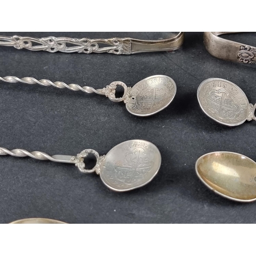 287 - Four pairs of silver tongs; together with a silver mounted pepperette; and seven silver and white me... 