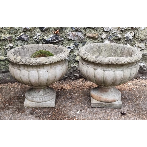 1645 - A pair of composition stone urns, 42cm high.