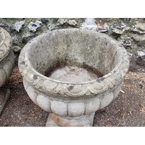 1645 - A pair of composition stone urns, 42cm high.