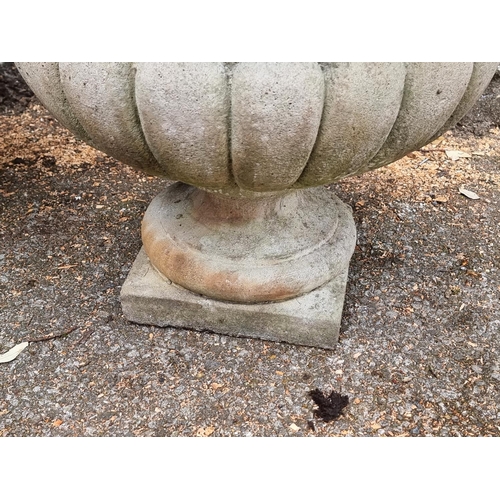 1645 - A pair of composition stone urns, 42cm high.