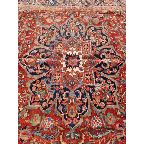 1659 - A Heriz carpet, having central floral medallion, with floral cartouches to each corner, with floral ... 