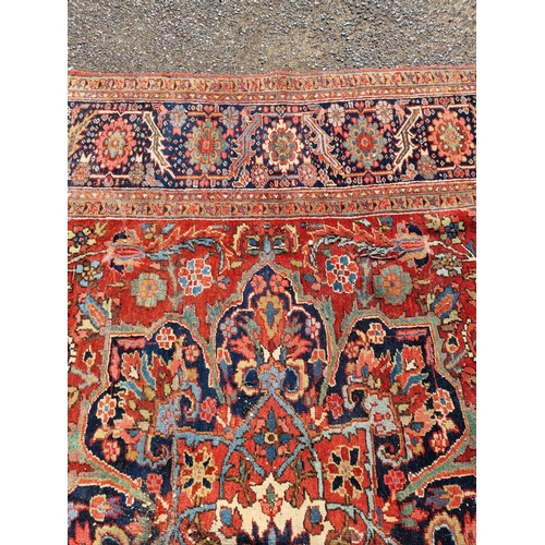 1659 - A Heriz carpet, having central floral medallion, with floral cartouches to each corner, with floral ... 