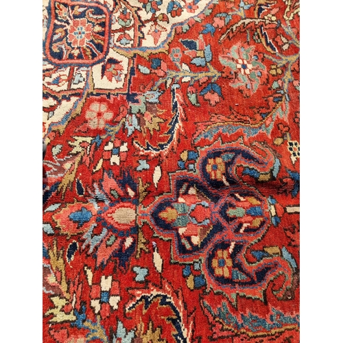 1659 - A Heriz carpet, having central floral medallion, with floral cartouches to each corner, with floral ... 