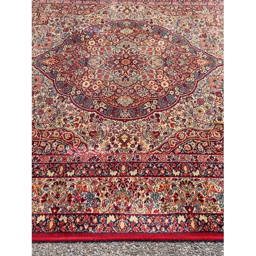 1660 - A large Persian rug, having central floral medallion, with floral borders, 305 x 205cm.... 