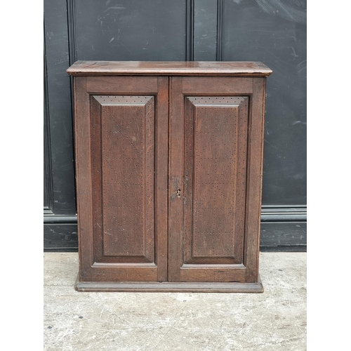 1002 - An 18th century oak panelled mural cupboard, with pierced geometric decoration to the doors, 85... 