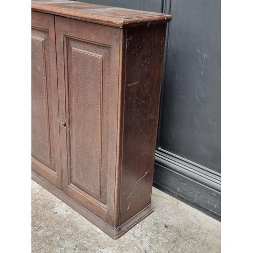 1002 - An 18th century oak panelled mural cupboard, with pierced geometric decoration to the doors, 85... 