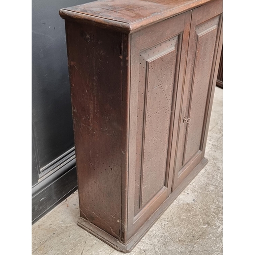 1002 - An 18th century oak panelled mural cupboard, with pierced geometric decoration to the doors, 85... 