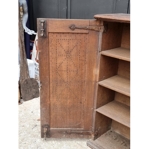 1002 - An 18th century oak panelled mural cupboard, with pierced geometric decoration to the doors, 85... 