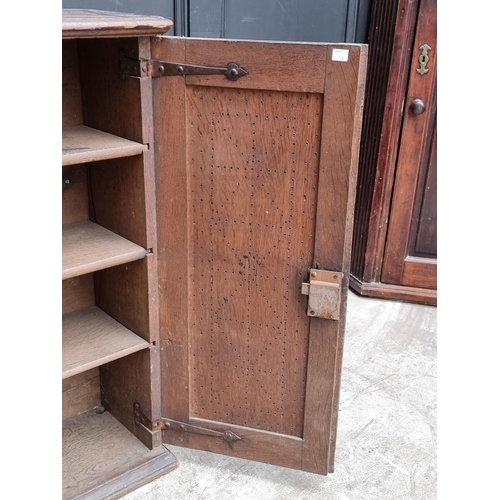 1002 - An 18th century oak panelled mural cupboard, with pierced geometric decoration to the doors, 85... 