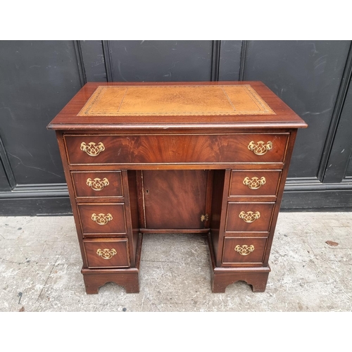 1004 - A reproduction mahogany kneehole desk, 76cm wide.