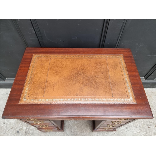 1004 - A reproduction mahogany kneehole desk, 76cm wide.