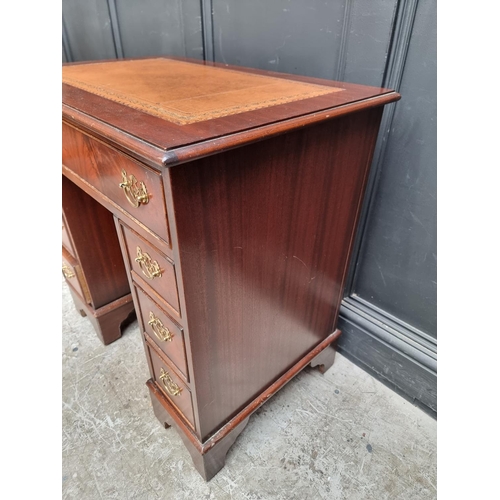 1004 - A reproduction mahogany kneehole desk, 76cm wide.