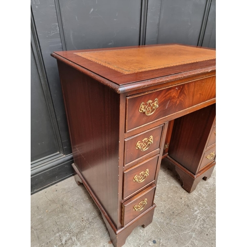 1004 - A reproduction mahogany kneehole desk, 76cm wide.