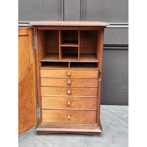 1014 - A small Gothic oak cupboard, opening to reveal drawers and pigeon holes, 53.5cm high x 33.5cm wide.... 