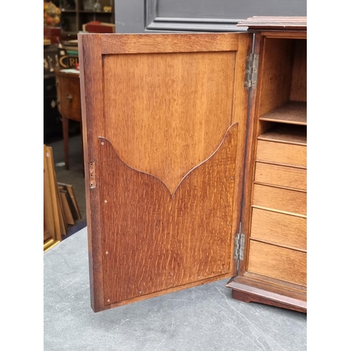 1014 - A small Gothic oak cupboard, opening to reveal drawers and pigeon holes, 53.5cm high x 33.5cm wide.... 