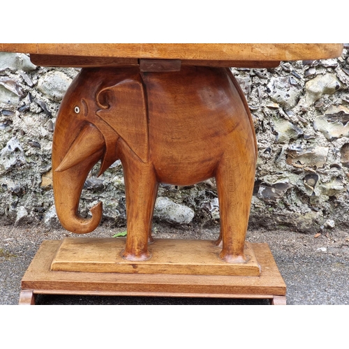 1023 - An Eastern teak elephant table, with ivory inset eyes, 82cm wide. DEFRA Ivory Act submission ref: GV... 