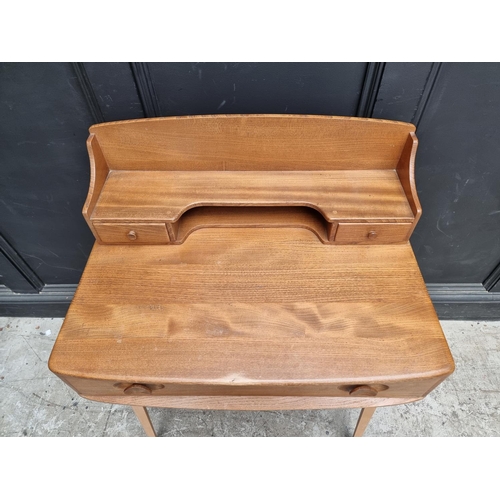 1028 - A mid-century Ercol elm and beech 439/479 writing desk, with blue sticker, 68.5cm wide.... 