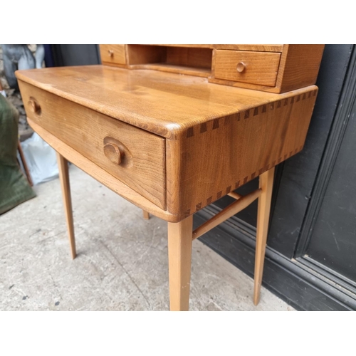 1028 - A mid-century Ercol elm and beech 439/479 writing desk, with blue sticker, 68.5cm wide.... 