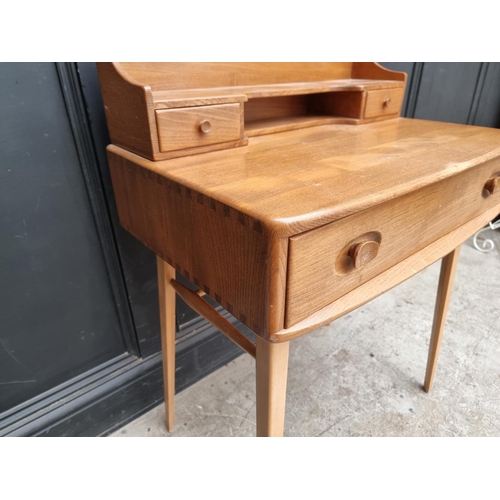 1028 - A mid-century Ercol elm and beech 439/479 writing desk, with blue sticker, 68.5cm wide.... 