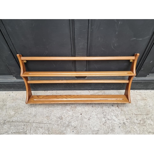 1030 - A mid-century Ercol elm hanging plate rack, 96.5cm wide.