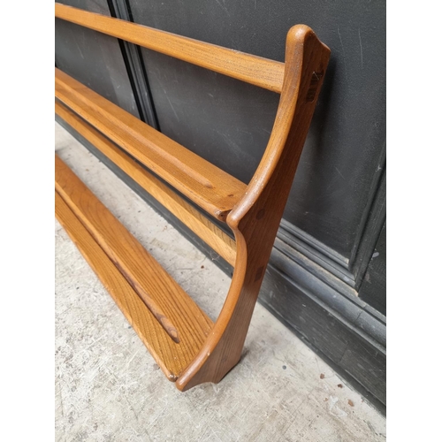 1030 - A mid-century Ercol elm hanging plate rack, 96.5cm wide.