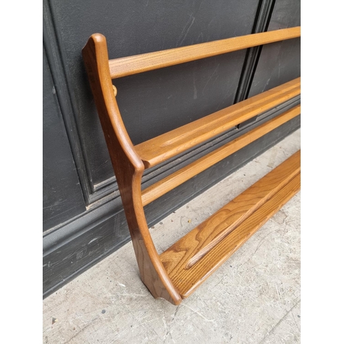 1030 - A mid-century Ercol elm hanging plate rack, 96.5cm wide.