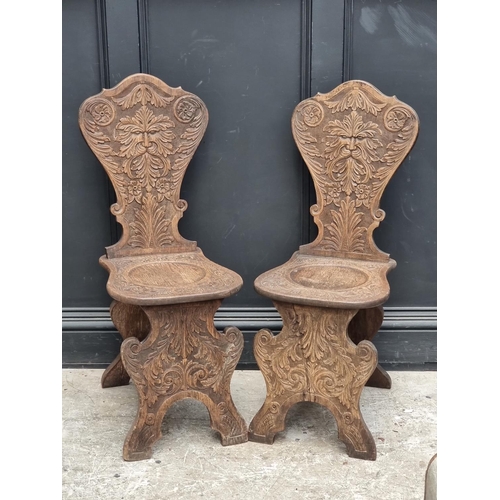 1079 - A pair of 17th century style carved oak 'Green Man' hall chairs.