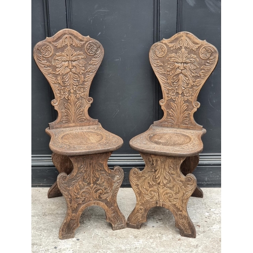 1079 - A pair of 17th century style carved oak 'Green Man' hall chairs.