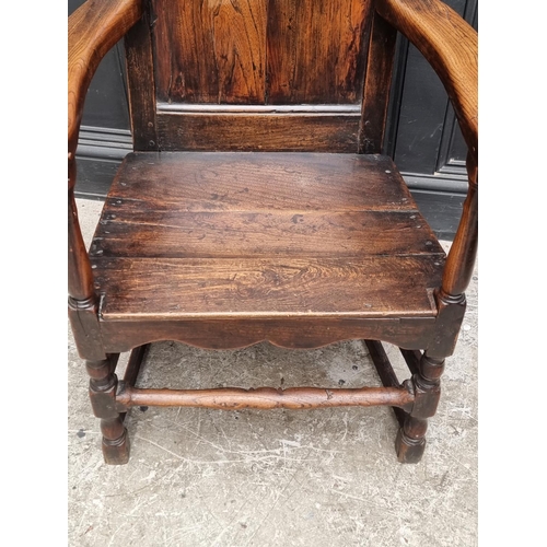 1088 - An 18th century oak panelled open arm elbow chair.