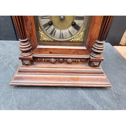 1197 - An early 20th century German HAC walnut mantel clock, 52cm high, with pendulum.... 