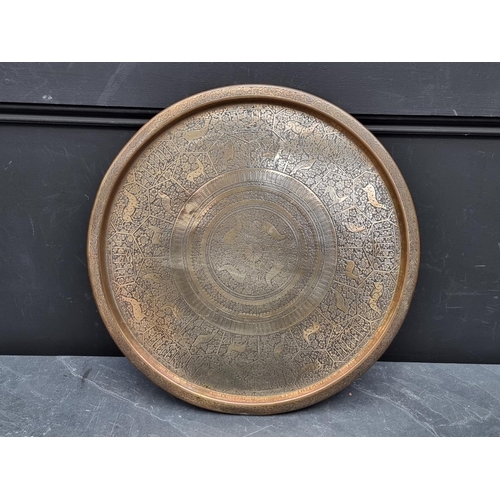 1205 - An Indian brass circular tray, decorated with stylised animals and panels of script, 46cm diame... 