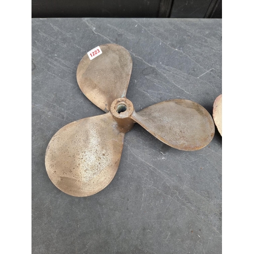 1223 - A bronze propeller, 29.5cm diameter; together with a similar smaller brass example. (2)... 