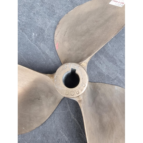 1223 - A bronze propeller, 29.5cm diameter; together with a similar smaller brass example. (2)... 