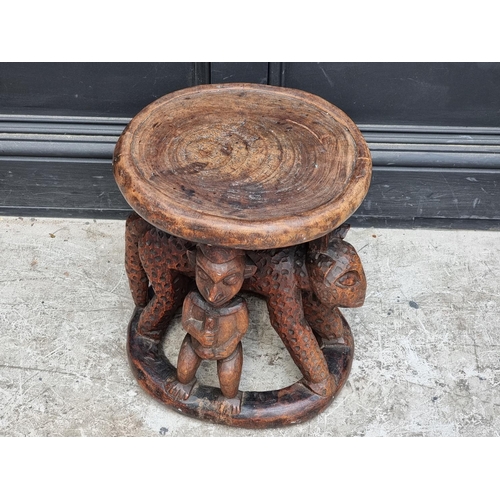 1348 - Ethnographica: an African tribal carved wood stool, possibly Yoruba, 41cm high.